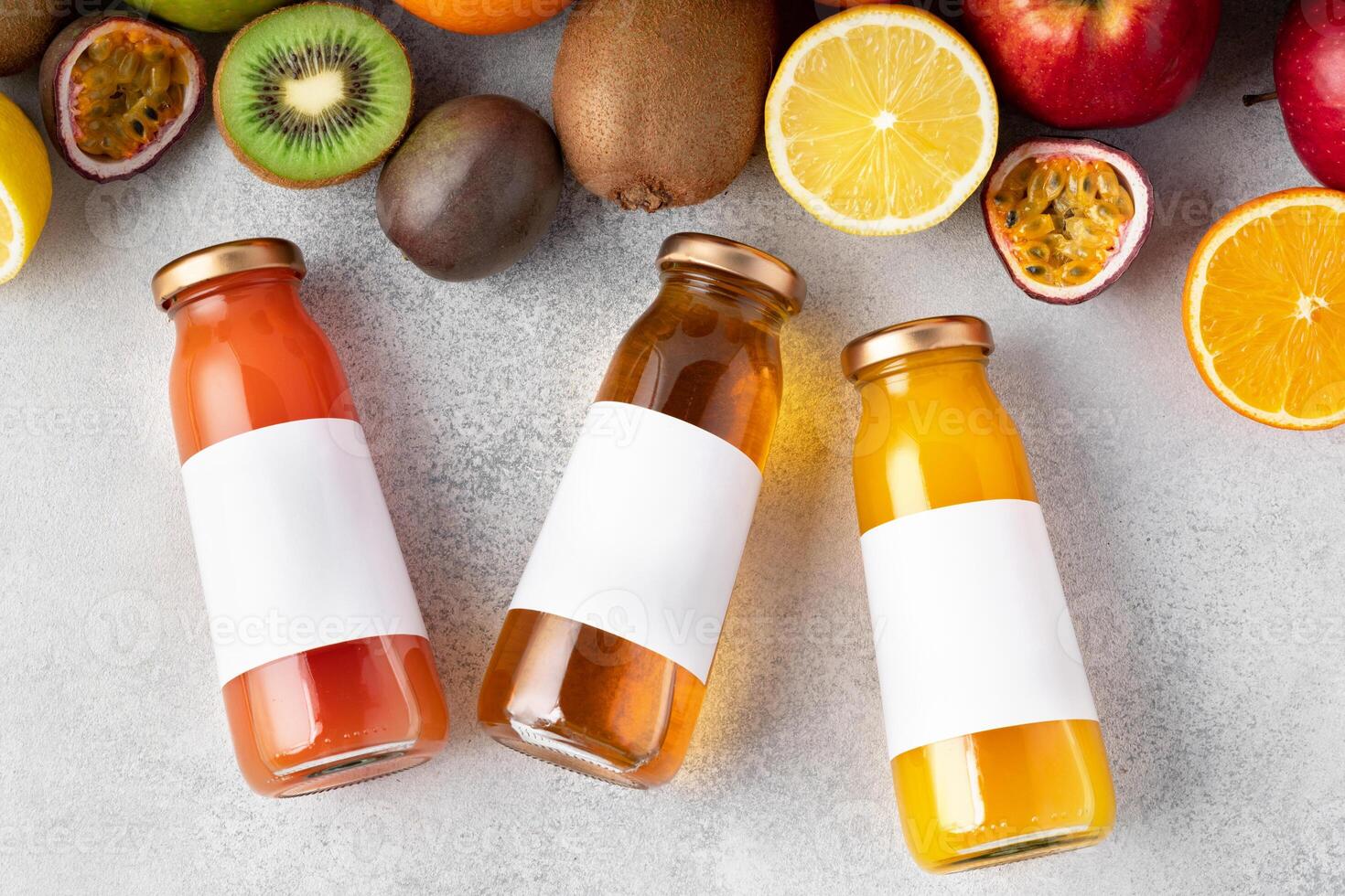 Various fruits and freshly squeezed fruits juice in bottle on gray background photo