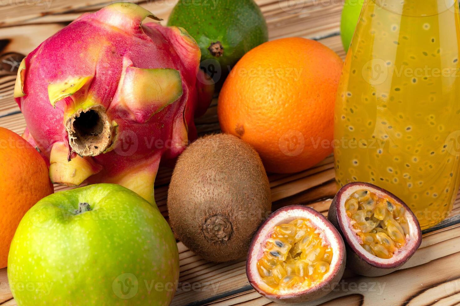 Fruit drink in glass bottle and frsh fruits on wooden background photo