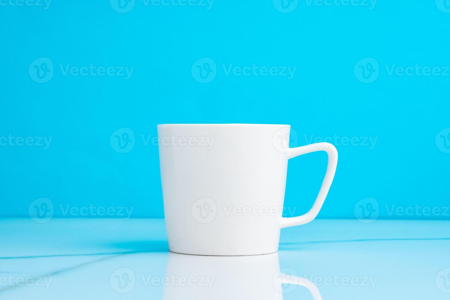 Ceramic mug on blue studio background close up photo