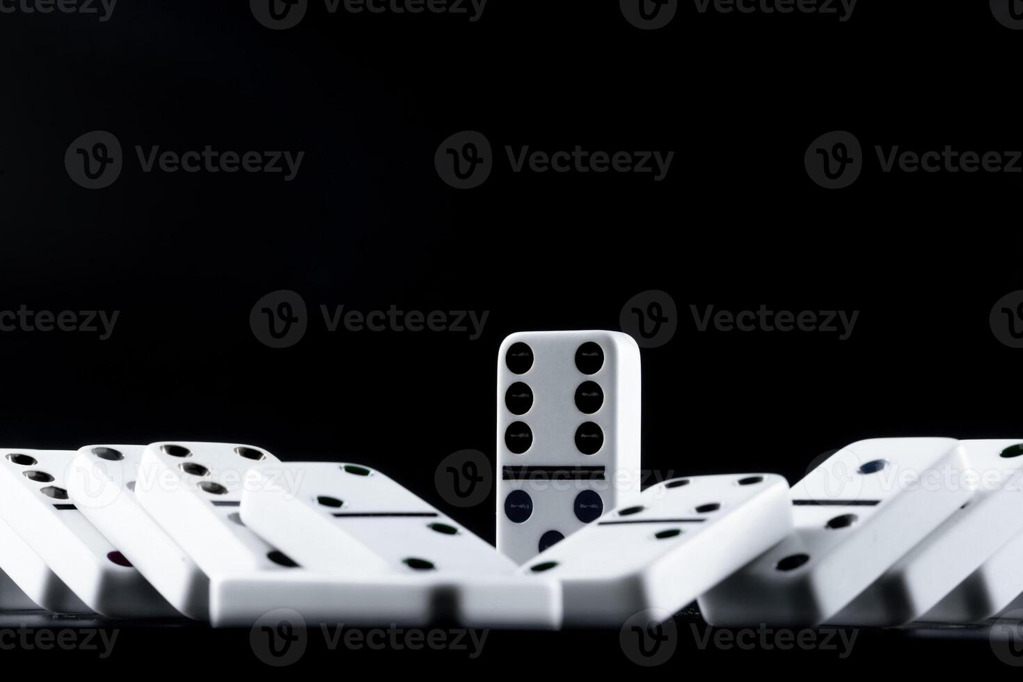 Domino pieces put in a row on black background photo