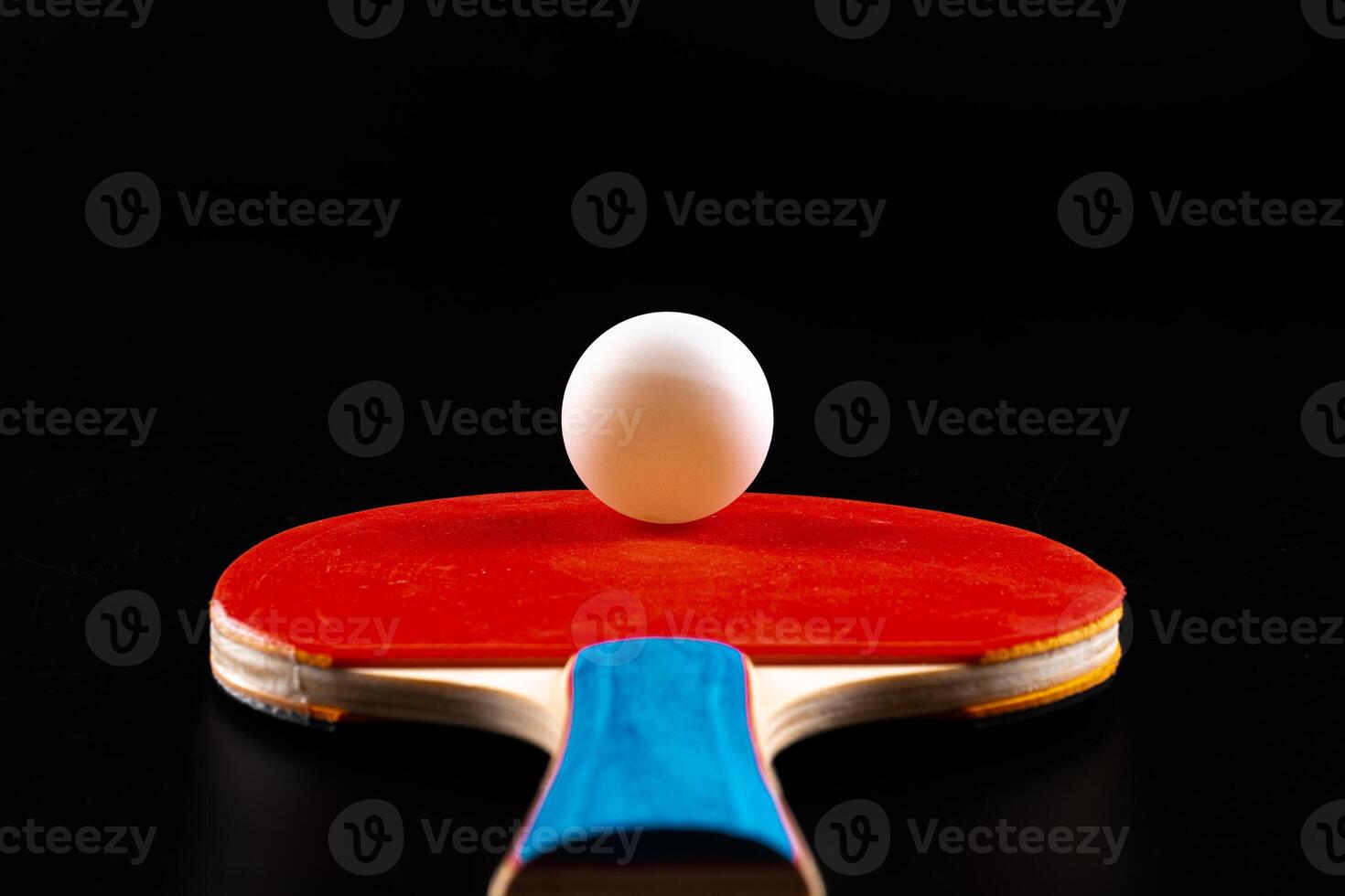 Red ping pong racket on dark background photo