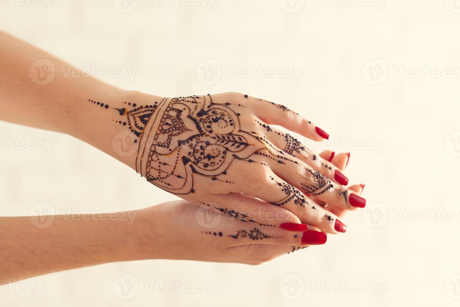 Red manicured hands with Mehndi photo