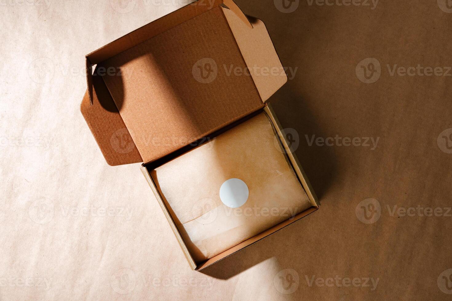 A sealed kraft box containing a wrapped item, positioned on a textured brown surface for an unboxing experience photo