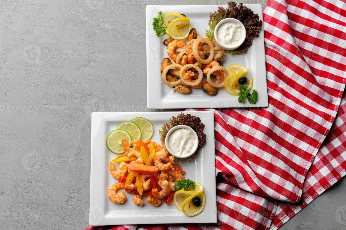 Cooked seafood on plate on gray background photo