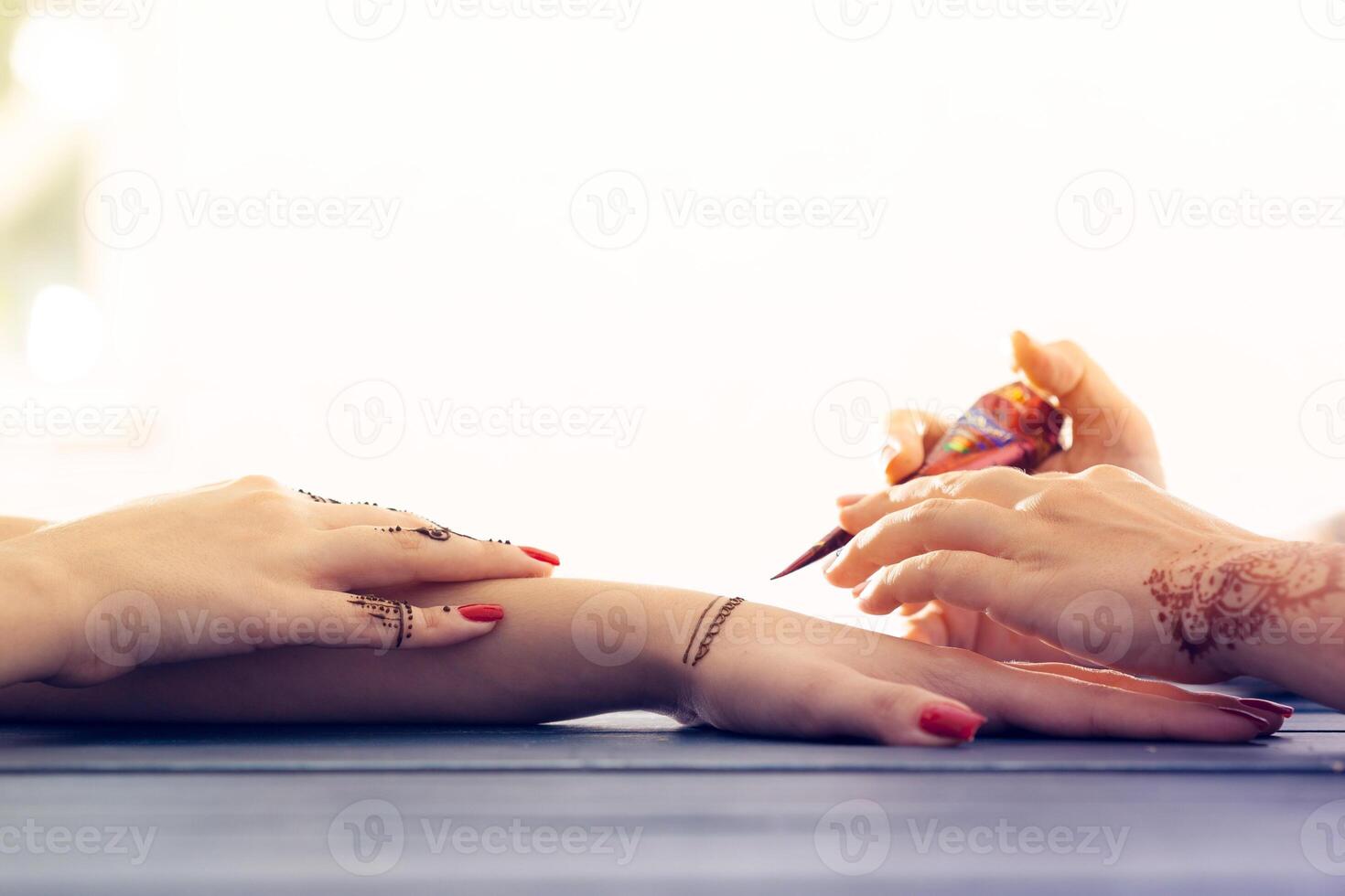 Process of applying mehndi on female hands photo