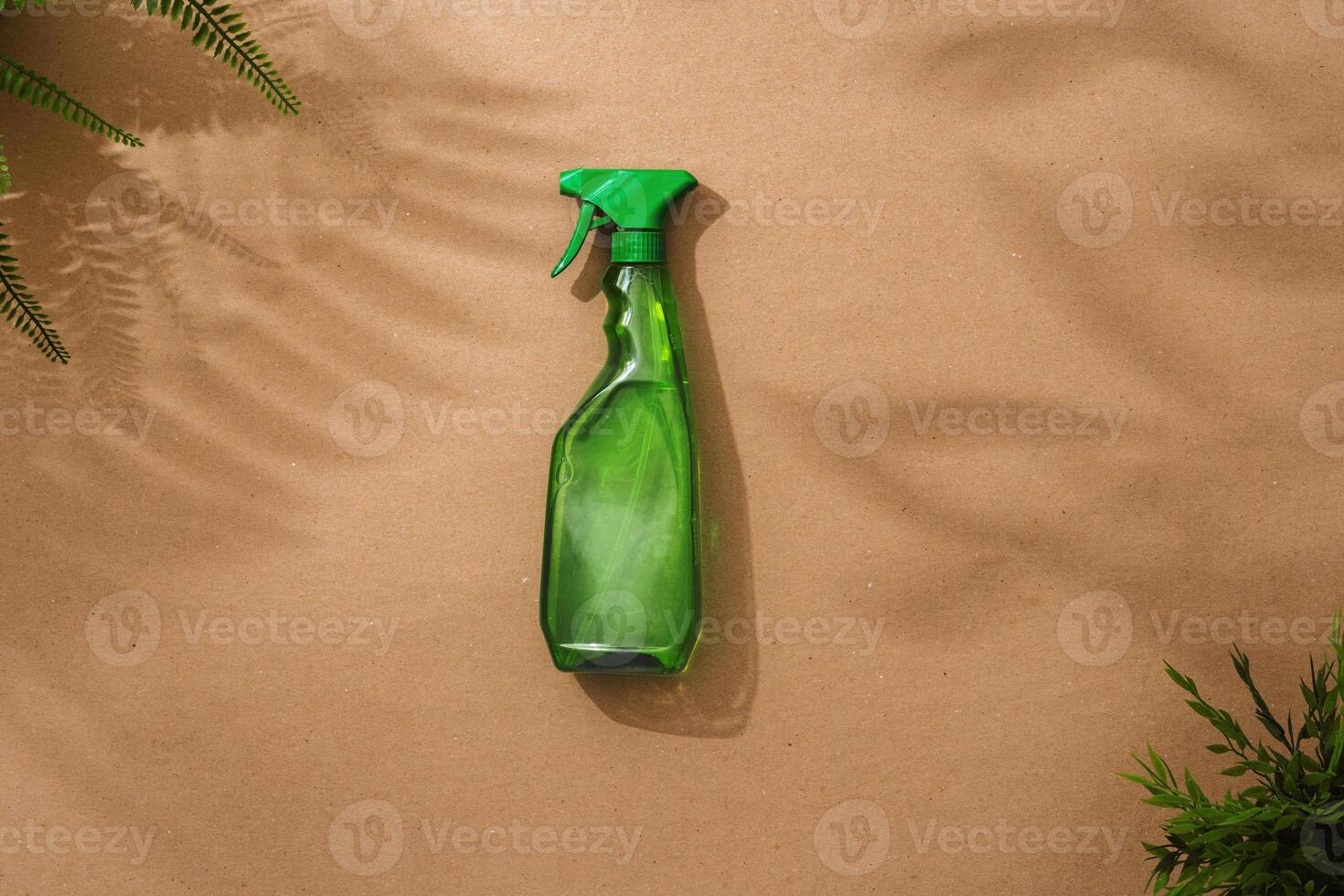 Green spray container of liquid detergent on beige background flat lay photo