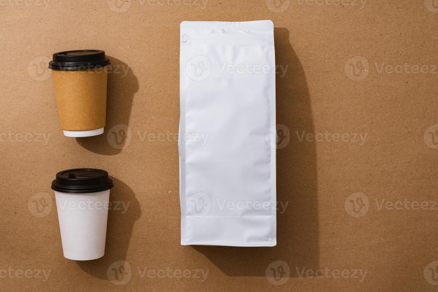Blank coffee package with copy space and takeout cups on beige background photo