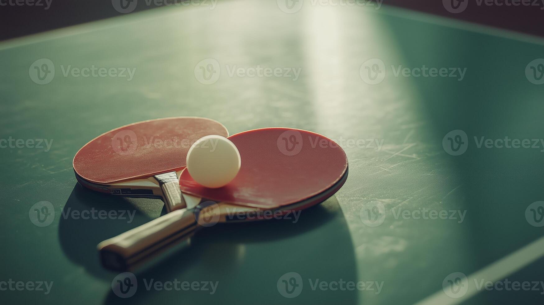 Table tennis paddles and ball resting on a green table in a sports facility during the late afternoon light photo