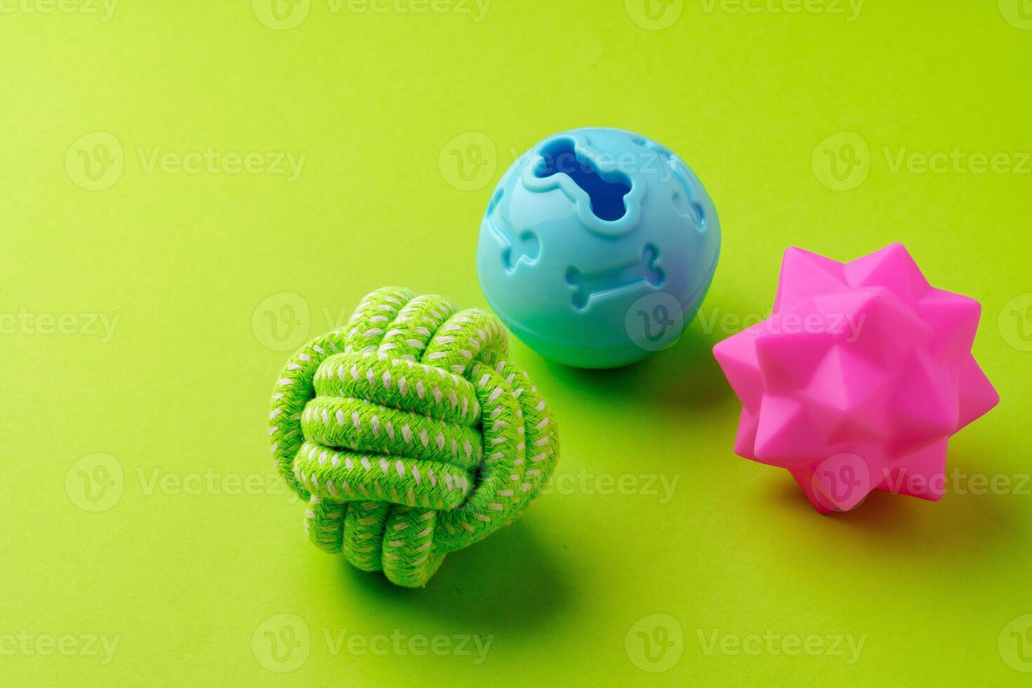 Colorful pet toys balls on green background photo