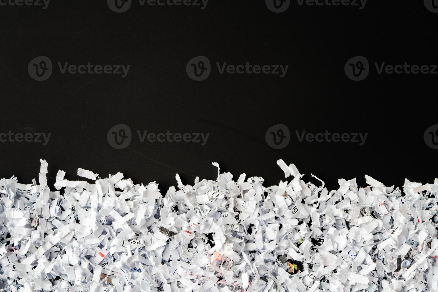 Shredded white paper on black background close up photo