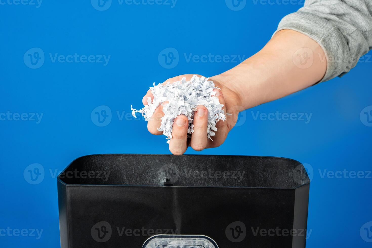 Male hand holding a bunch of shredded paper photo