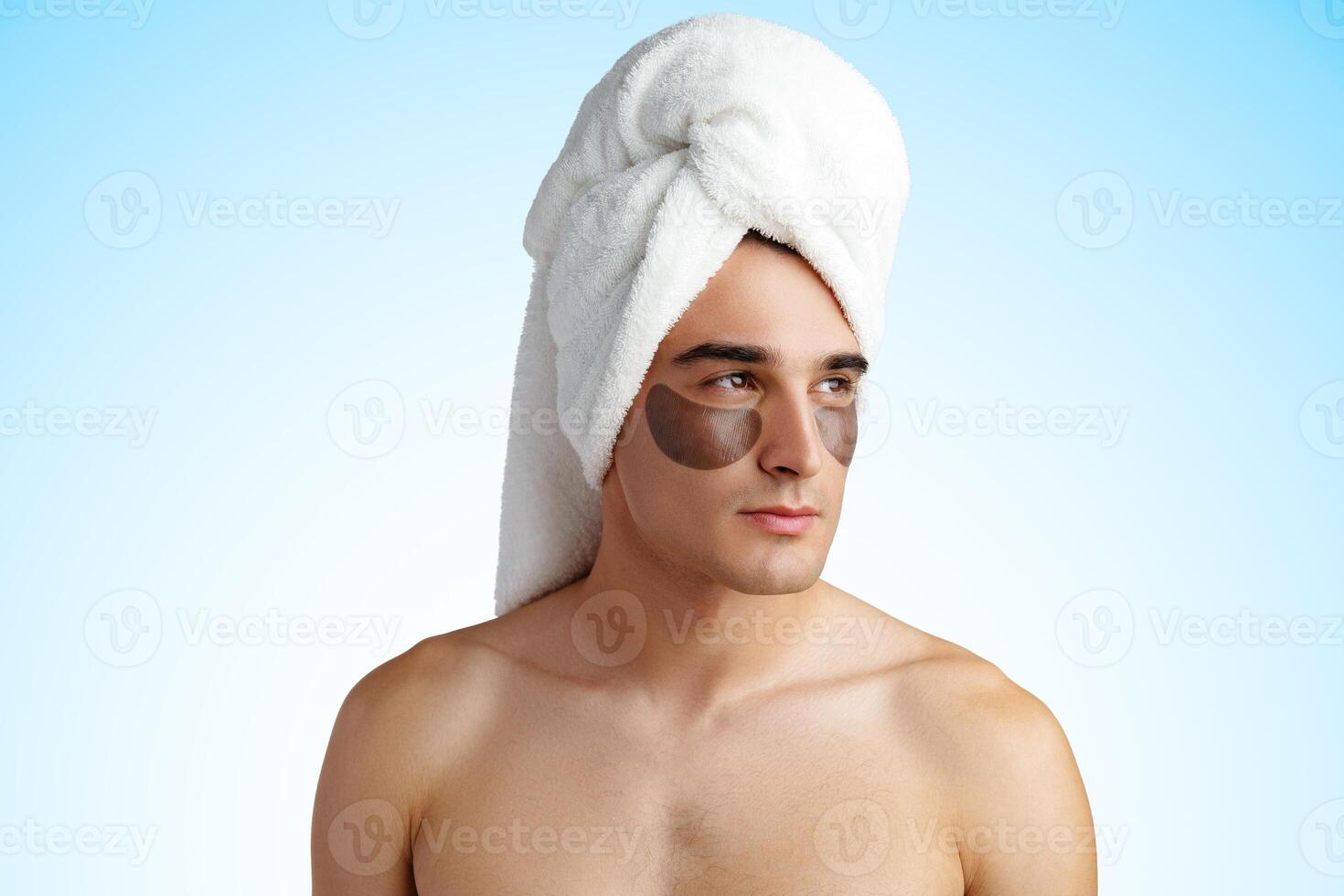 Portrait of attractive young male model with eye patches on white background photo