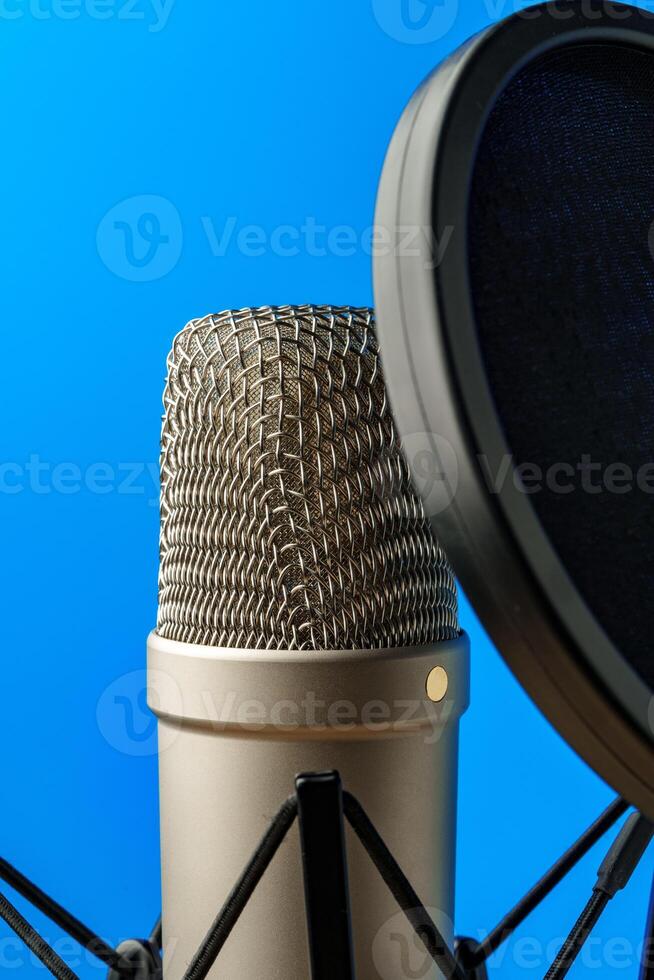 Professional microphone stand over blue studio background photo