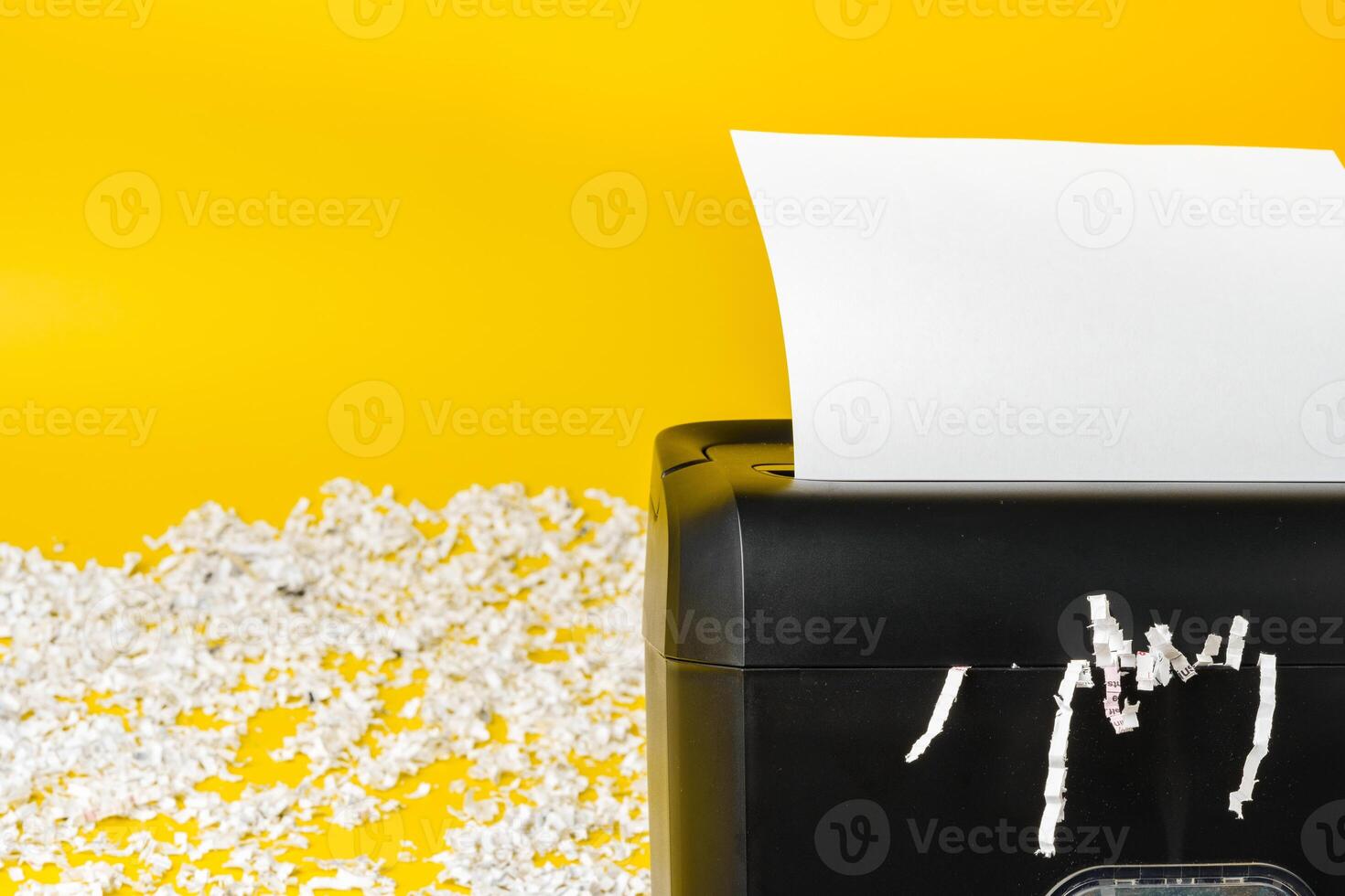Office paper shredder on yellow studio background photo