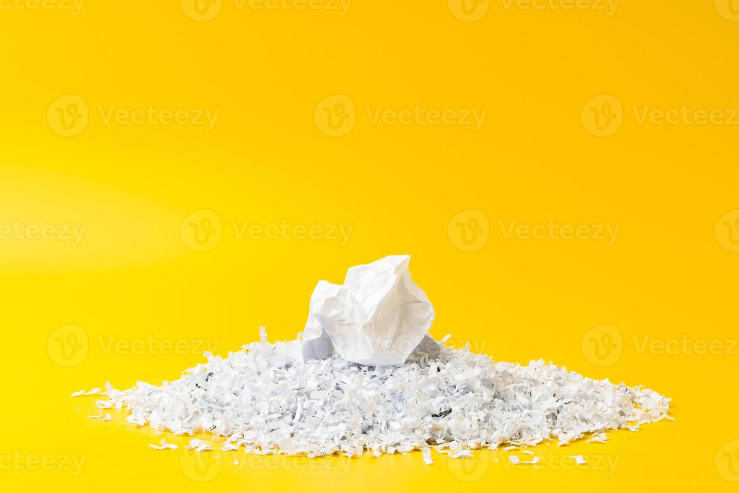 Shredded white paper on light yellow background photo