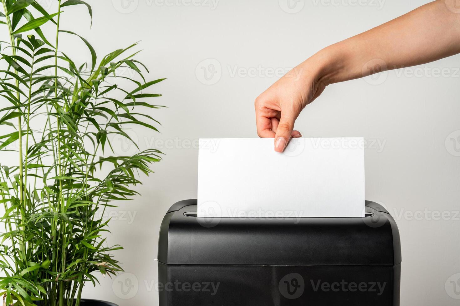 Black paper shredder cutting paper on gray background photo