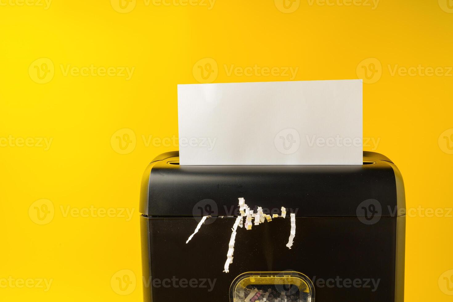 Office paper shredder on yellow studio background photo
