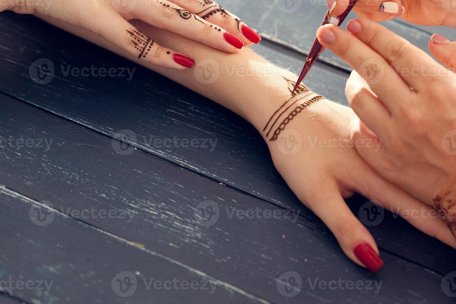 Process of applying mehndi on female hands photo