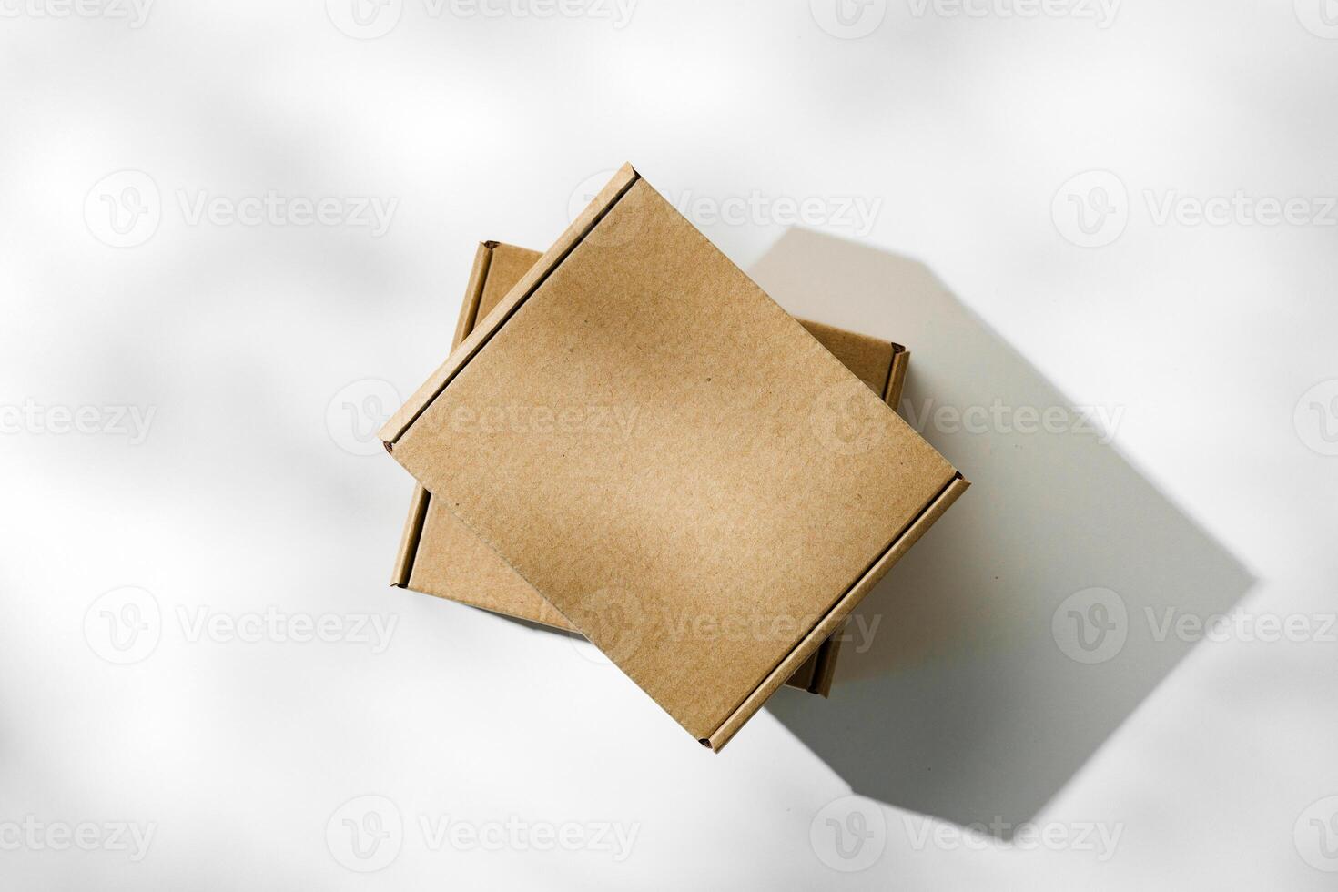 Three brown cardboard boxes arranged on a light surface with soft shadows photo