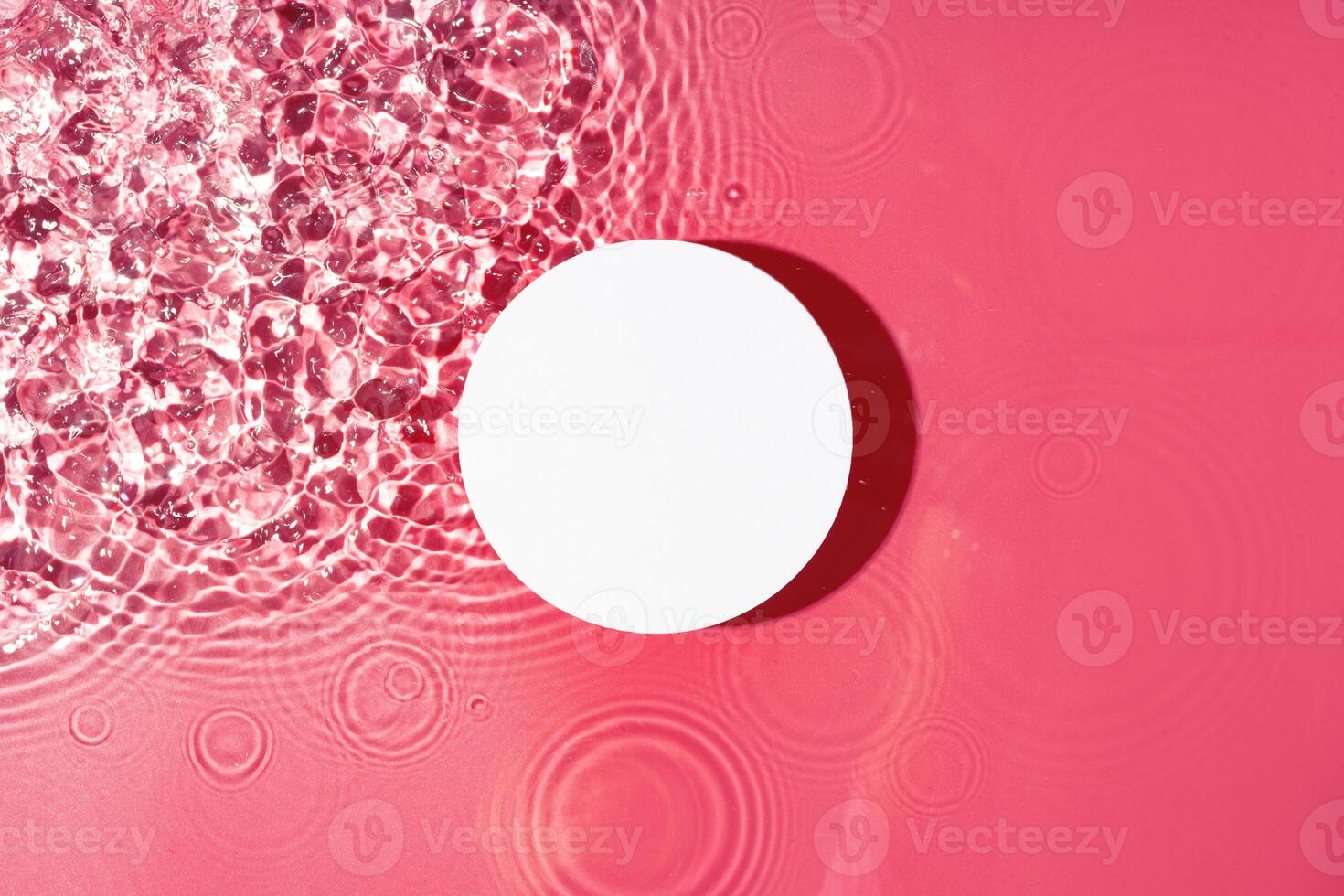 Bright circular object floating on water with pink ripples in a serene setting during daylight photo