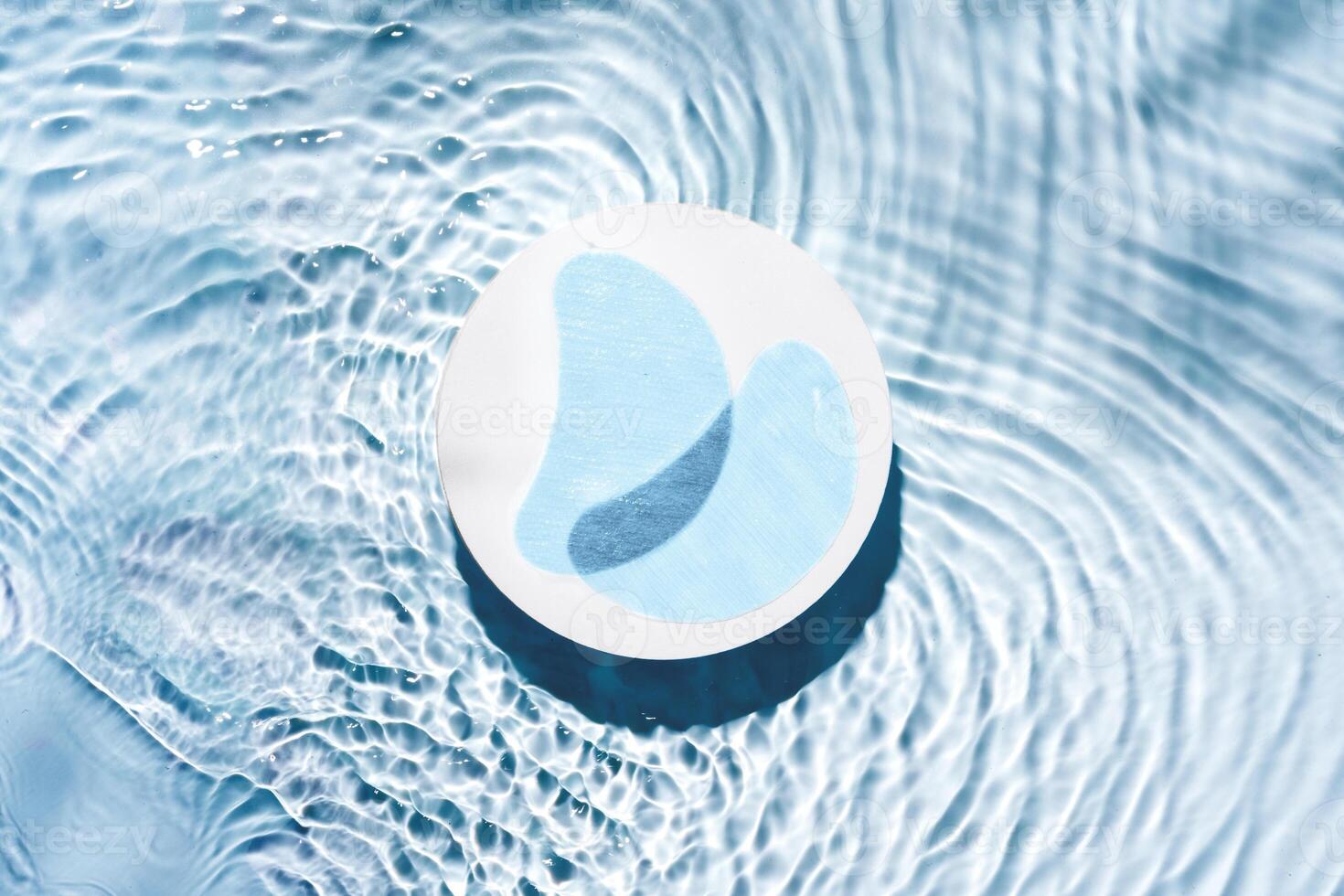 Eye patches floating on clear water with gentle ripples photo
