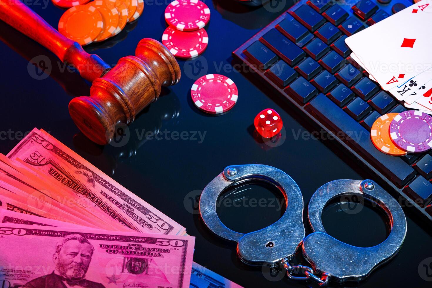 Handcuffs placed beside cash and poker chips on a black table at a dimly lit gambling setting photo