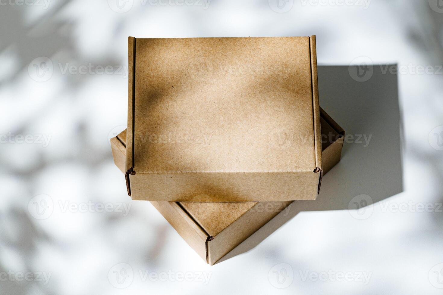 Freshly packed cardboard boxes resting on a white surface, illuminated by soft natural light photo