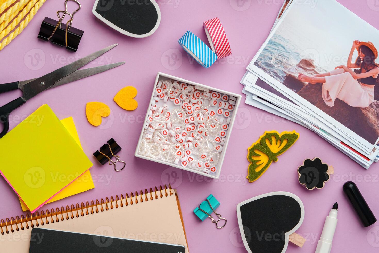 Crafting supplies for scrapbooking arranged on a purple surface photo