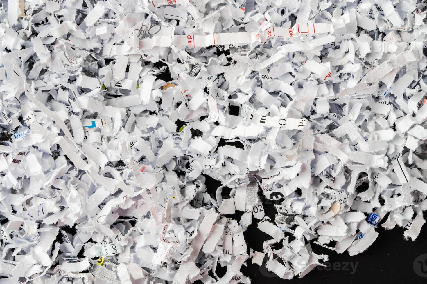 Shredded white paper on black background close up photo