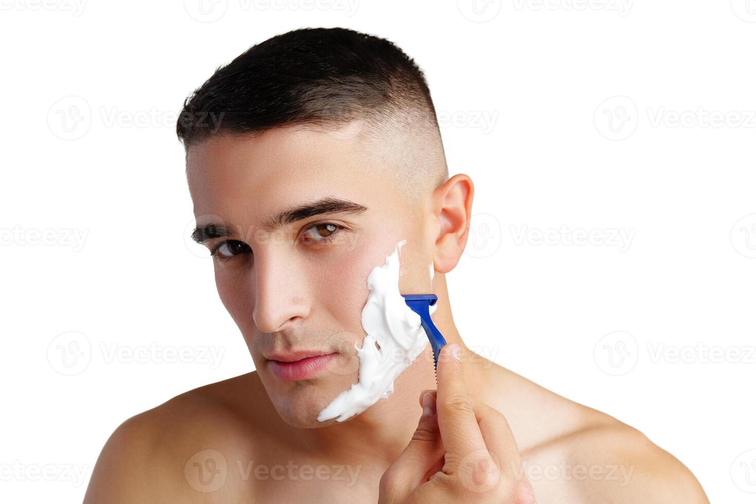 Young handsome man applying shaving foam against white background photo