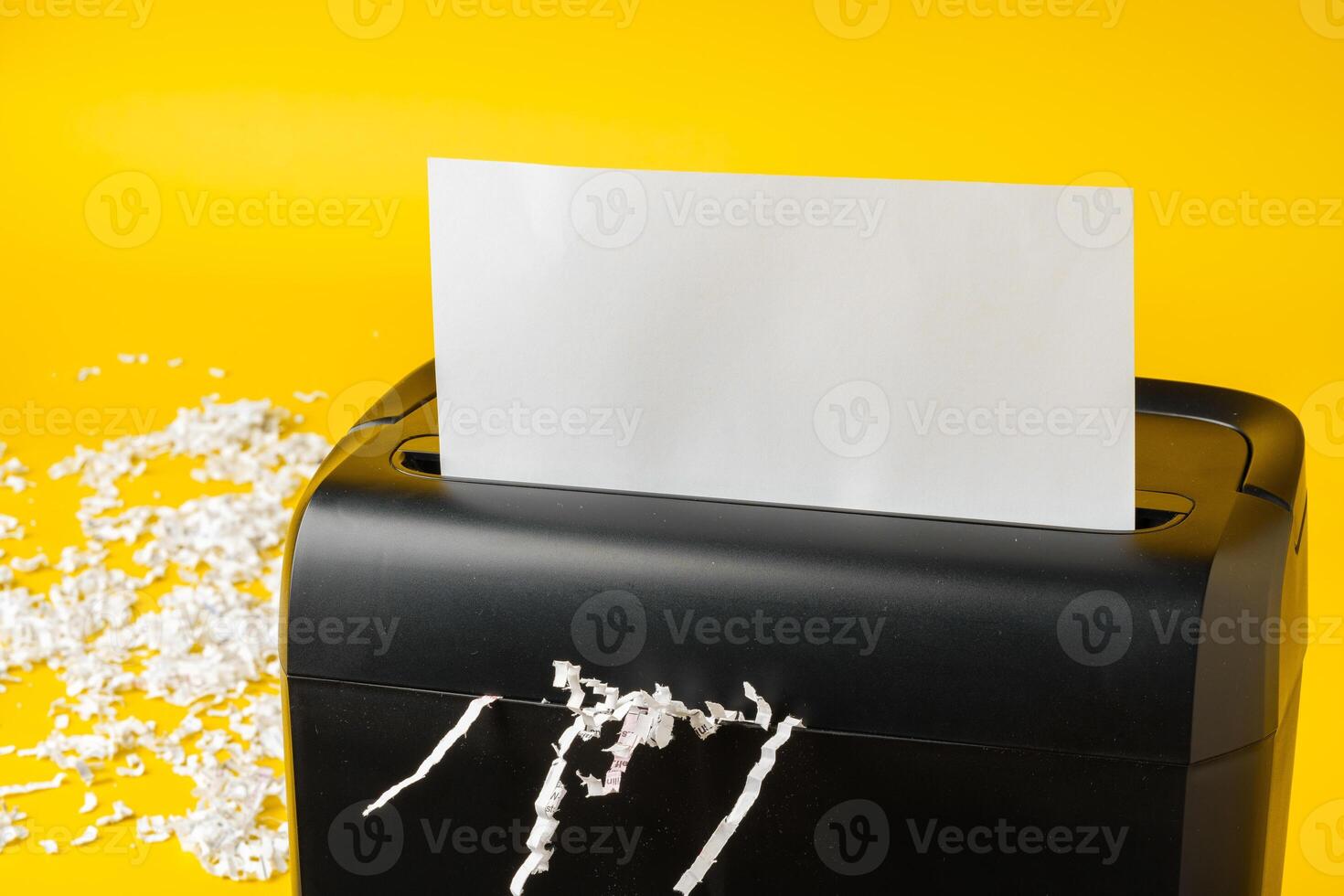 Office paper shredder on yellow studio background photo