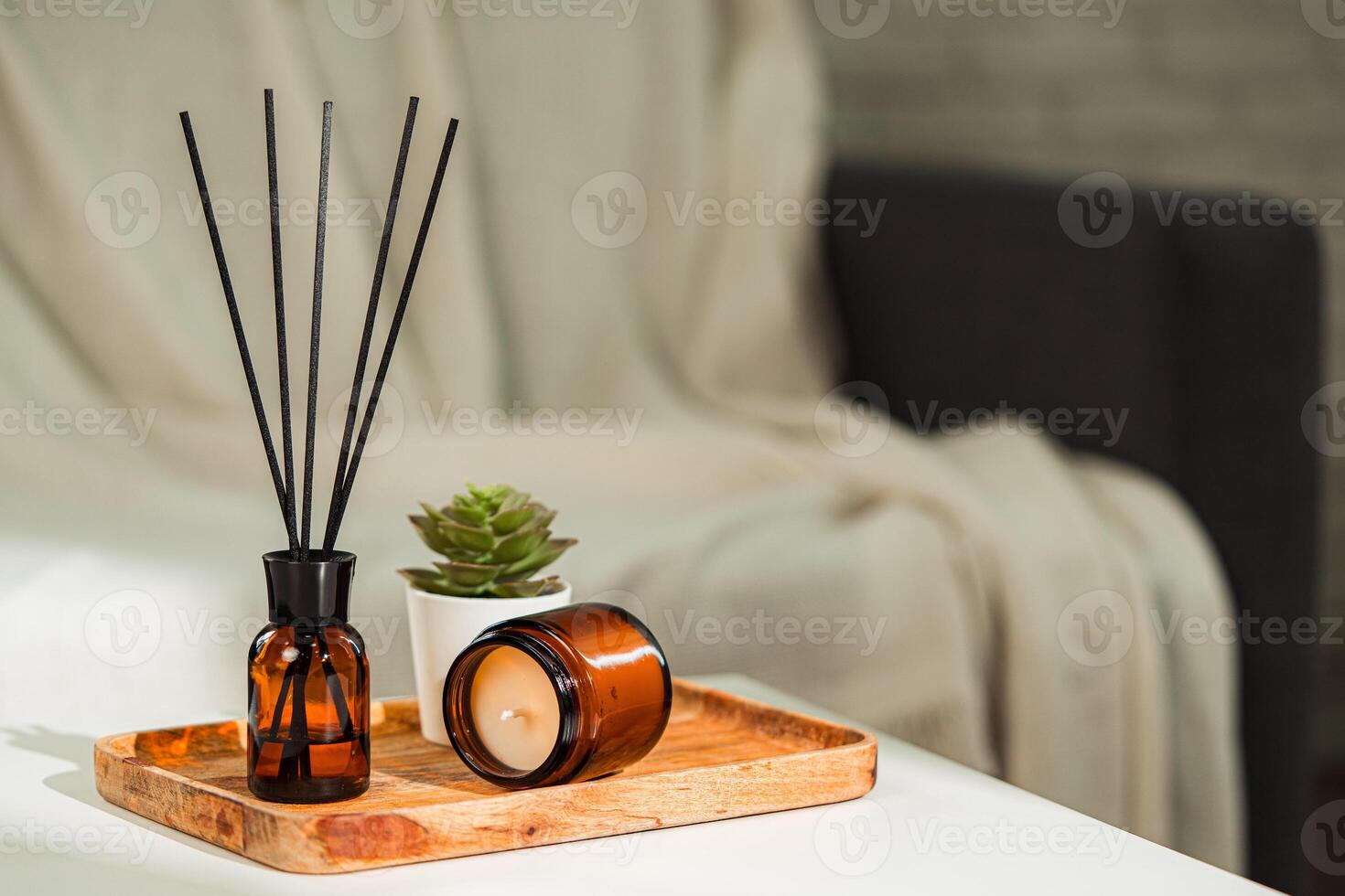Aromatic reed freshener and candle on table in room photo