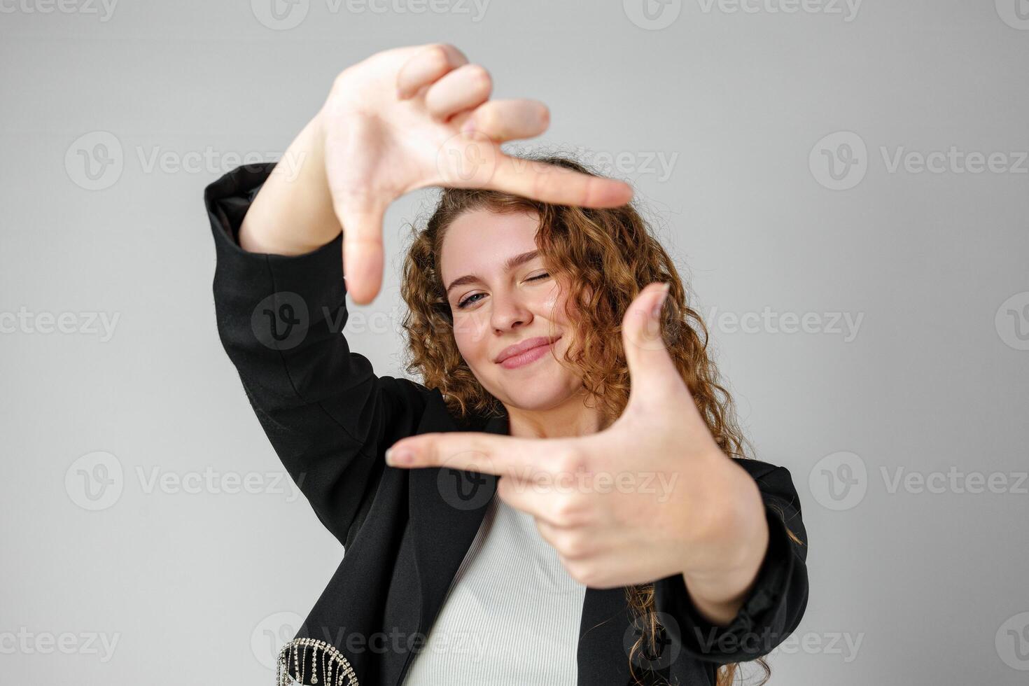 Woman Making Hand Gesture Picture Frame in Studio photo