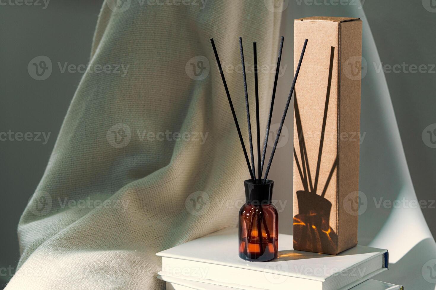 Liquid home perfume in glass diffuser with sticks on chair photo