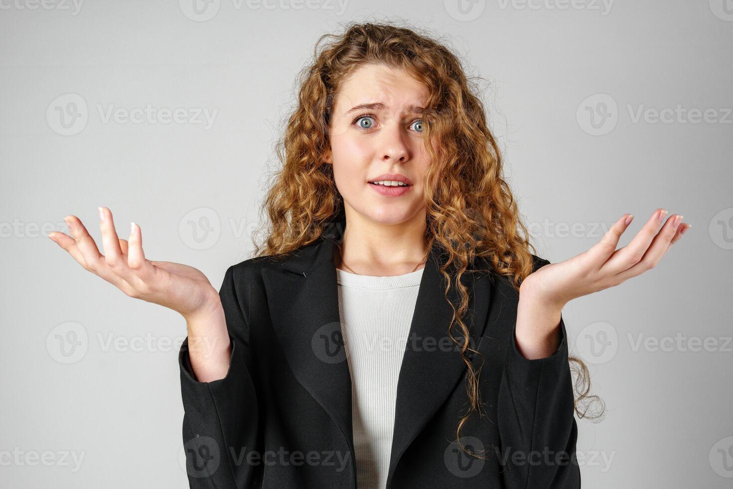 Young Curly Clueless Woman Holding Out Hands photo