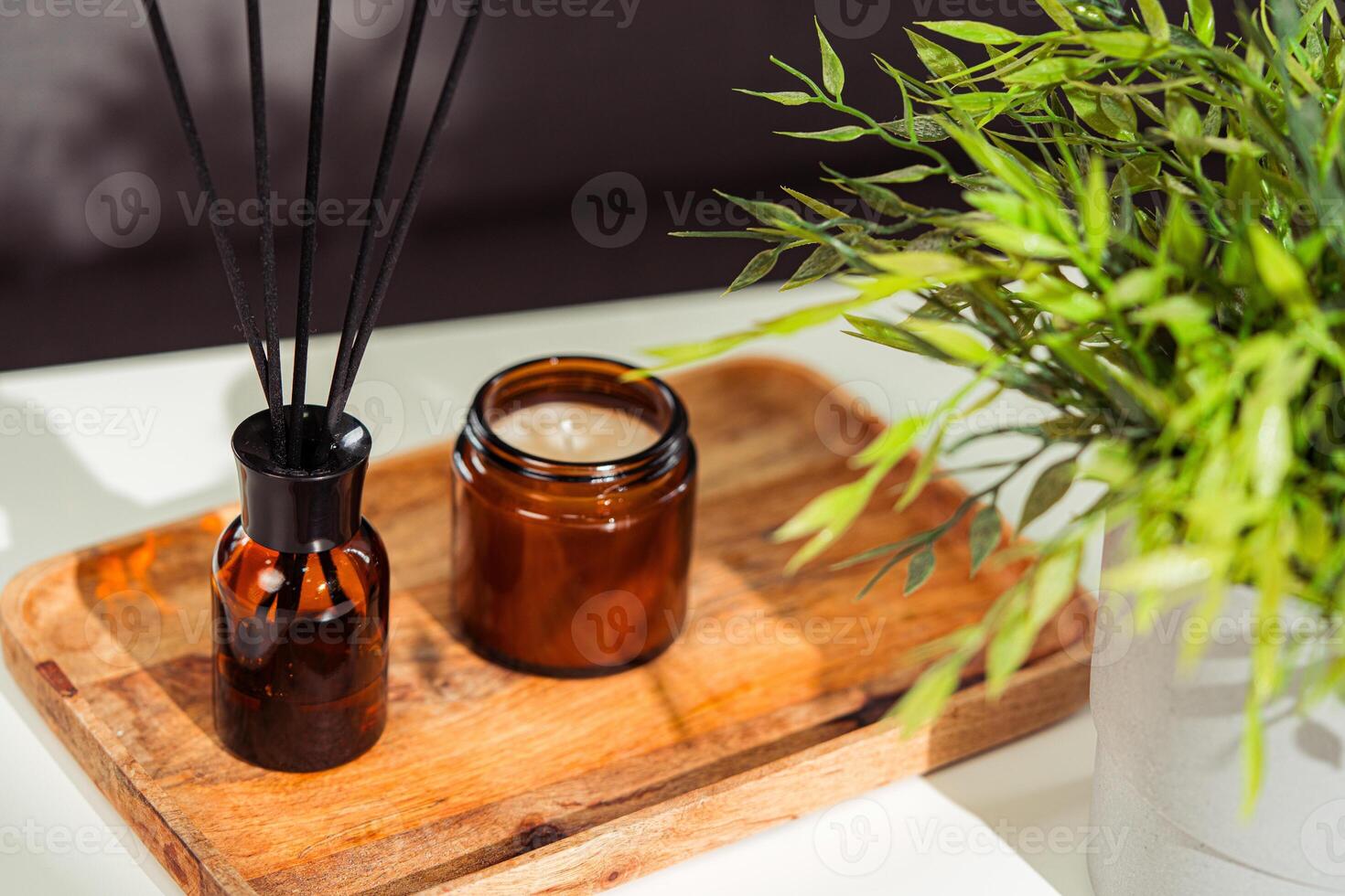 Aromatic reed freshener and candle on table in room photo