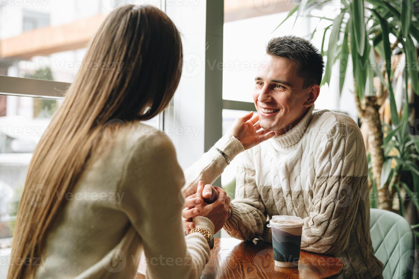 Smiling Man Engaged in a Casual Conversation at a Cozy Cafe During Daytime photo