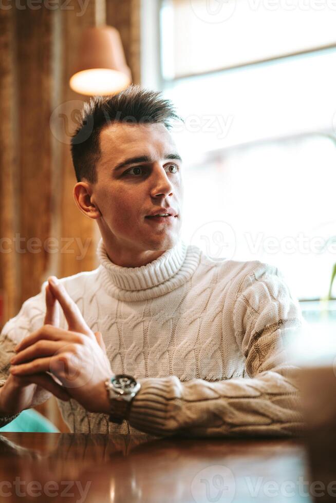 Man Sitting at Table With Hands Raised photo
