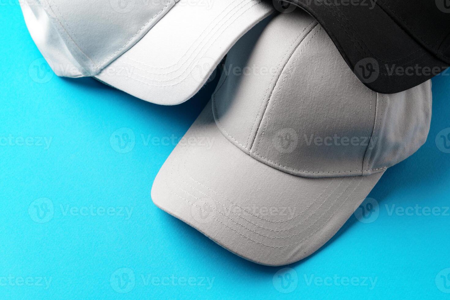 Baseball caps on blue background studio shot photo