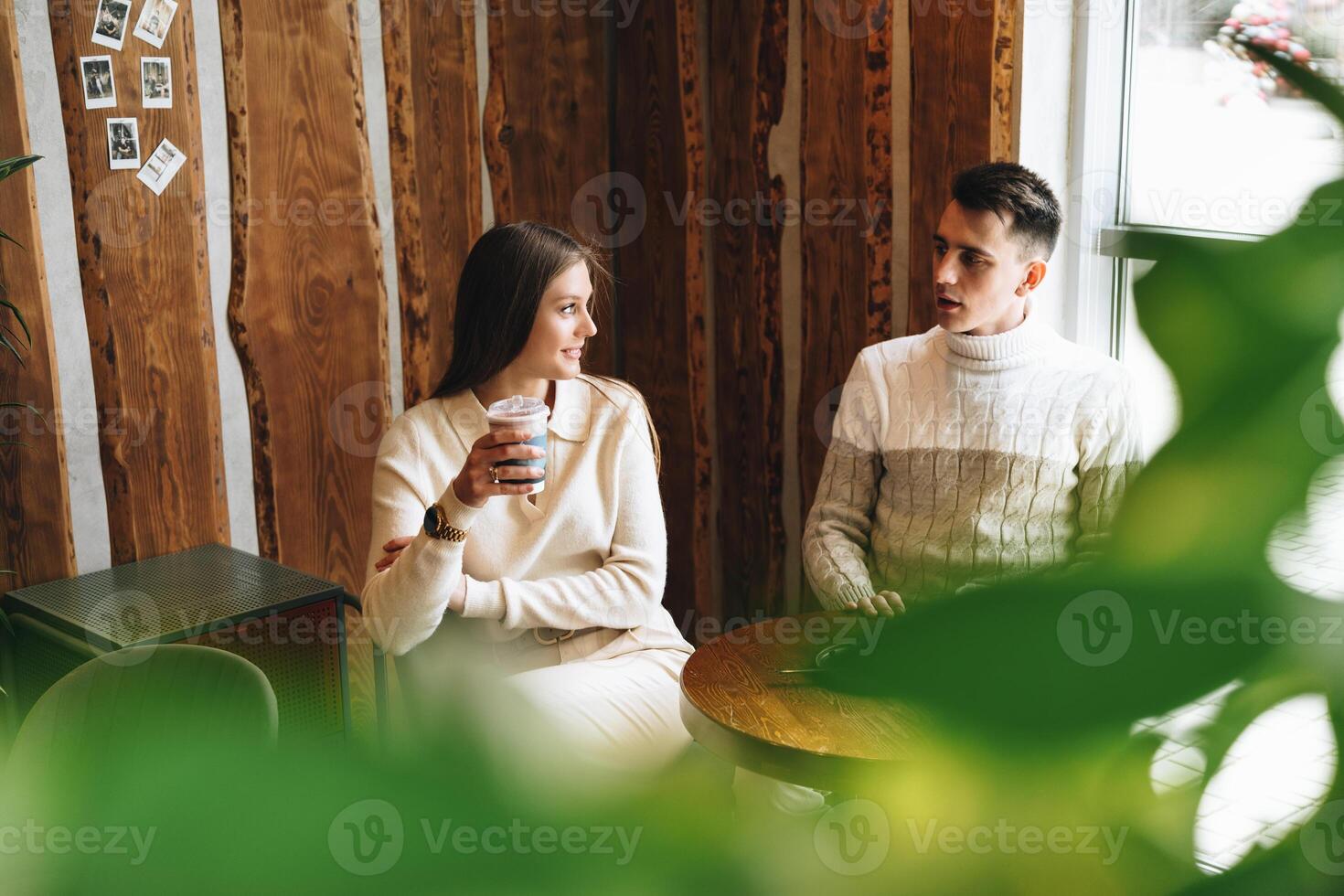 Two People Engaged in Casual Conversation at a Cozy Cafe During the Day photo