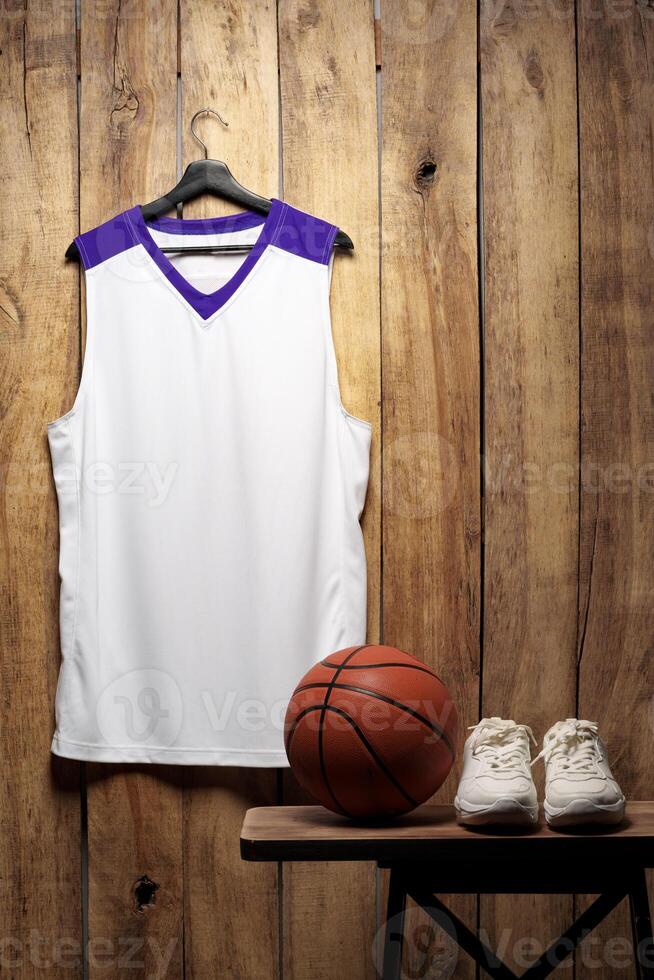 White sneakers and basketball ball against wooden background photo