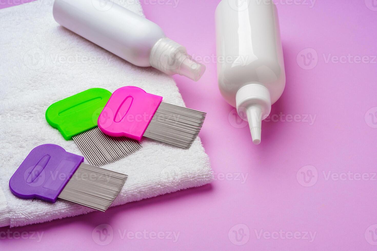 Anti lice combs and towel on pink background photo
