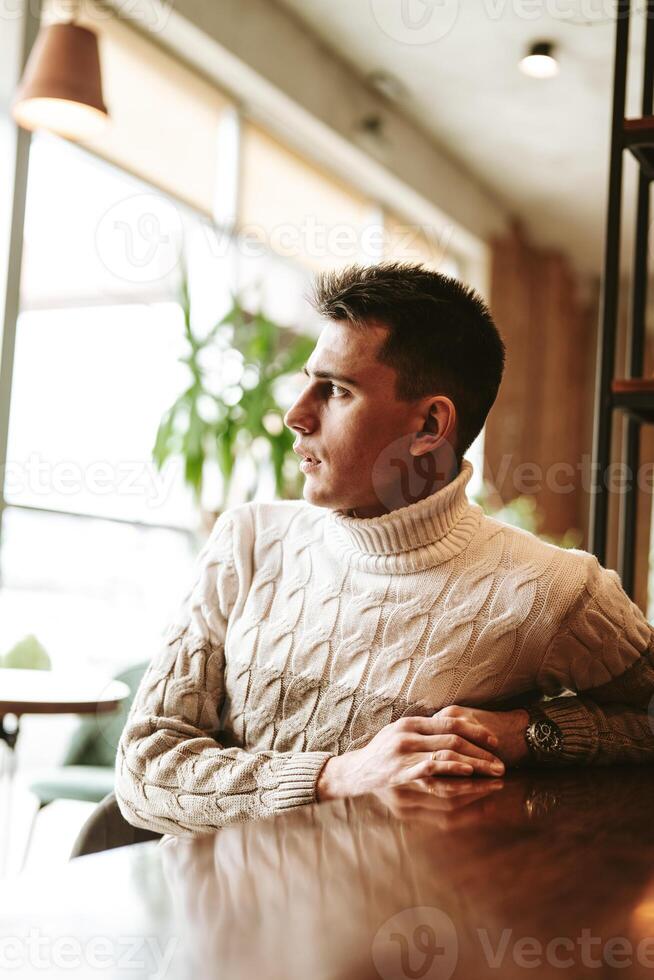 Man Sitting at a Table With Arms Crossed photo