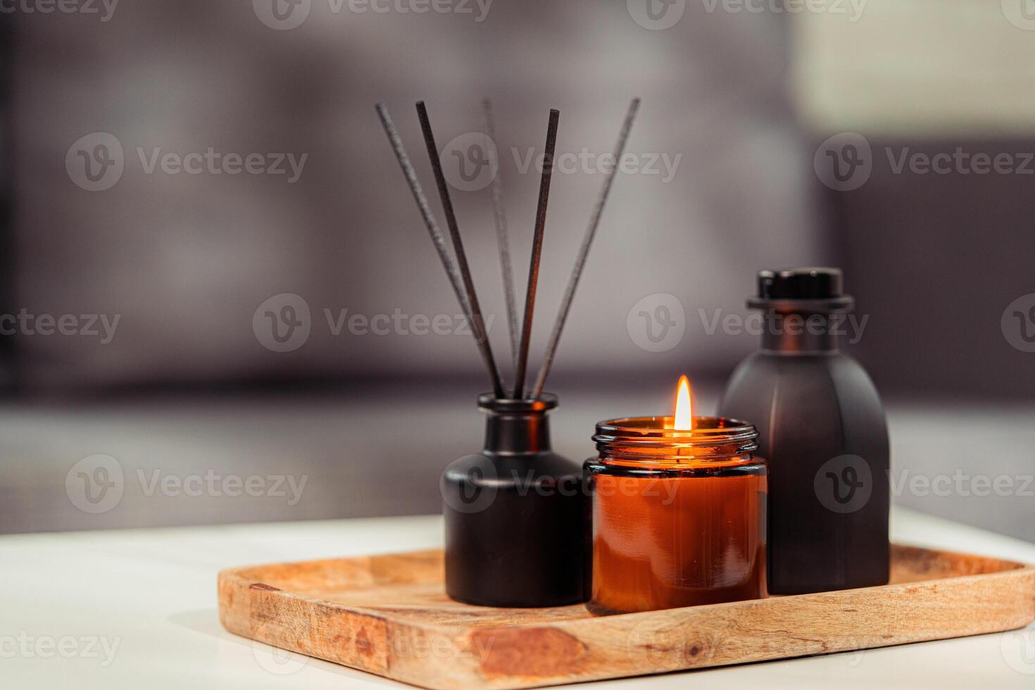 Aromatic reed freshener and candle on table in room photo