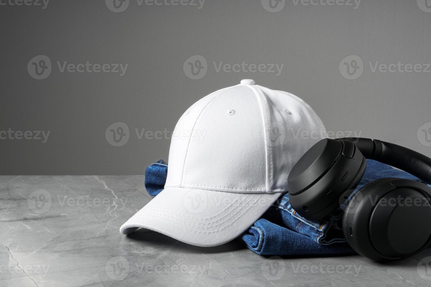 Baseball cap with black headphones on dark background photo