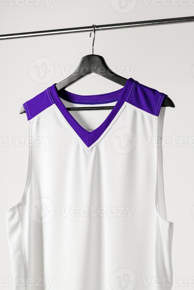 White basketball jersey hanging against white background photo
