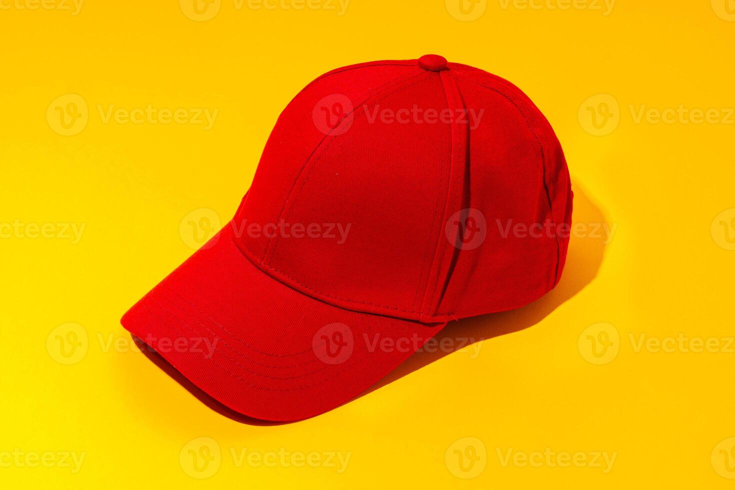 Baseball hat against yellow background in studio photo