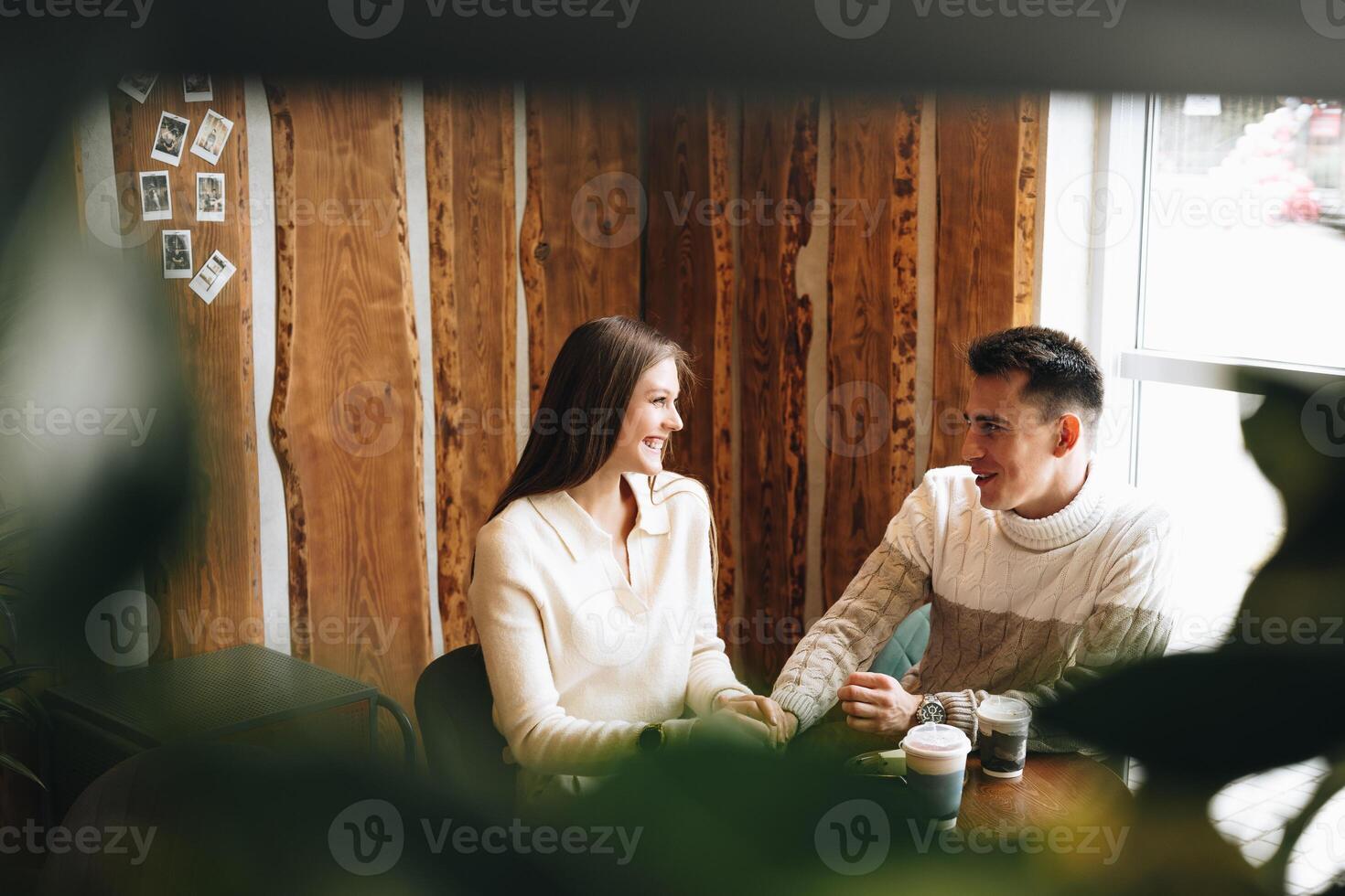 Two People Engaged in Casual Conversation at a Cozy Cafe During the Day photo