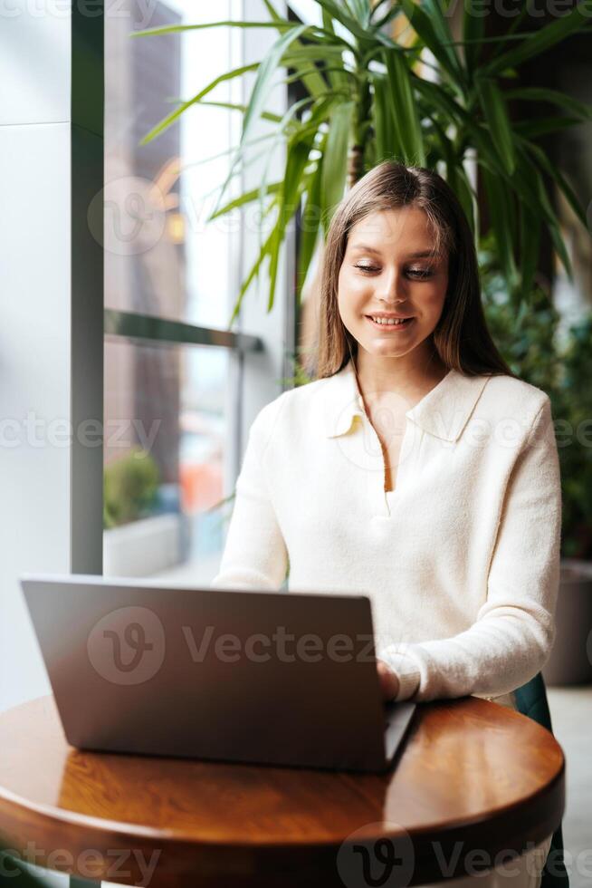 Woman Sitting at Table Using Laptop Computer photo