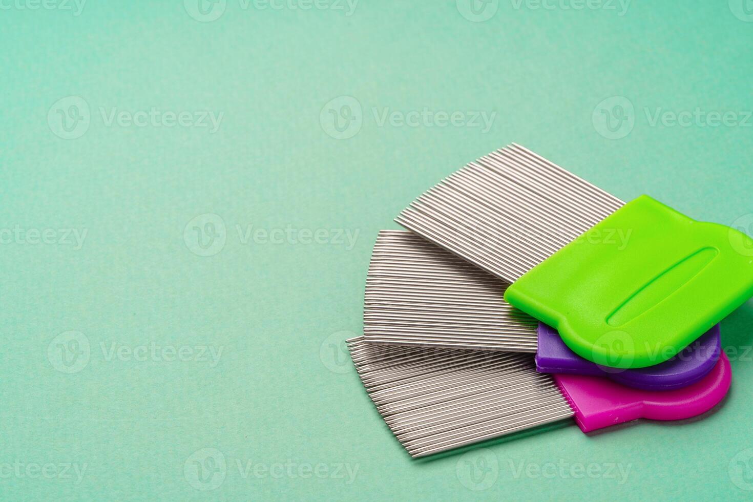 Three combs for lice removing on green background photo